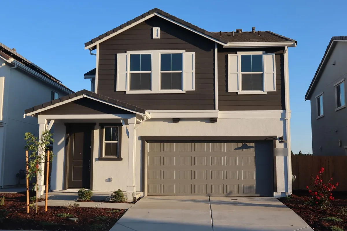 Newly built two-story house with a concrete driveway running to its garage